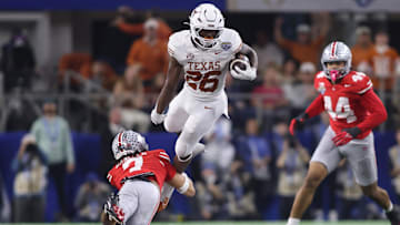 Jan 10, 2025; Arlington, Texas, USA; Texas Longhorns running back Quintrevion Wisner (26) is tackled by Ohio State Buckeyes cornerback Jordan Hancock (7) during the third quarter of the College Football Playoff semifinal in the Cotton Bowl at AT&T Stadium. Mandatory Credit: Tim Heitman-Imagn Images
