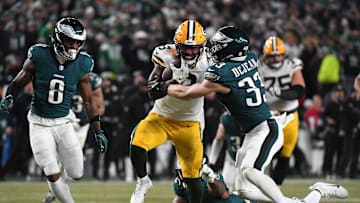 Jan 12, 2025; Philadelphia, Pennsylvania, USA; Green Bay Packers running back Josh Jacobs (8) rushes the ball against Philadelphia Eagles cornerback Cooper DeJean (33) during the second half in an NFC wild card game at Lincoln Financial Field. Mandatory Credit: Eric Hartline-Imagn Images