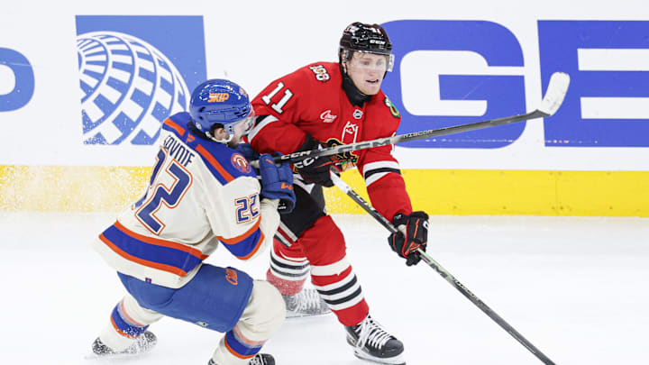 Jan 12, 2026; Chicago, Illinois, USA; Edmonton Oilers center Matt Savoie (22) defends against Chicago Blackhawks center Oliver Moore (11) during the third period at United Center. Mandatory Credit: Kamil Krzaczynski-Imagn Images