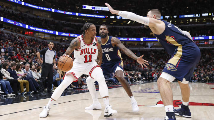 Dec 2, 2023; Chicago, Illinois, USA; Chicago Bulls forward DeMar DeRozan (11) is defended by New Orleans Pelicans forward Naji Marshall (8) and  center Jonas Valanciunas (17) during the second half at United Center. Mandatory Credit: Kamil Krzaczynski-USA TODAY Sports