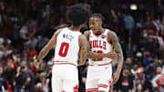 Dec 2, 2023; Chicago, Illinois, USA; Chicago Bulls guard Coby White (0) celebrates with guard Ayo Dosunmu (12) after defeating the New Orleans Pelicans at United Center. Mandatory Credit: Kamil Krzaczynski-Imagn Images