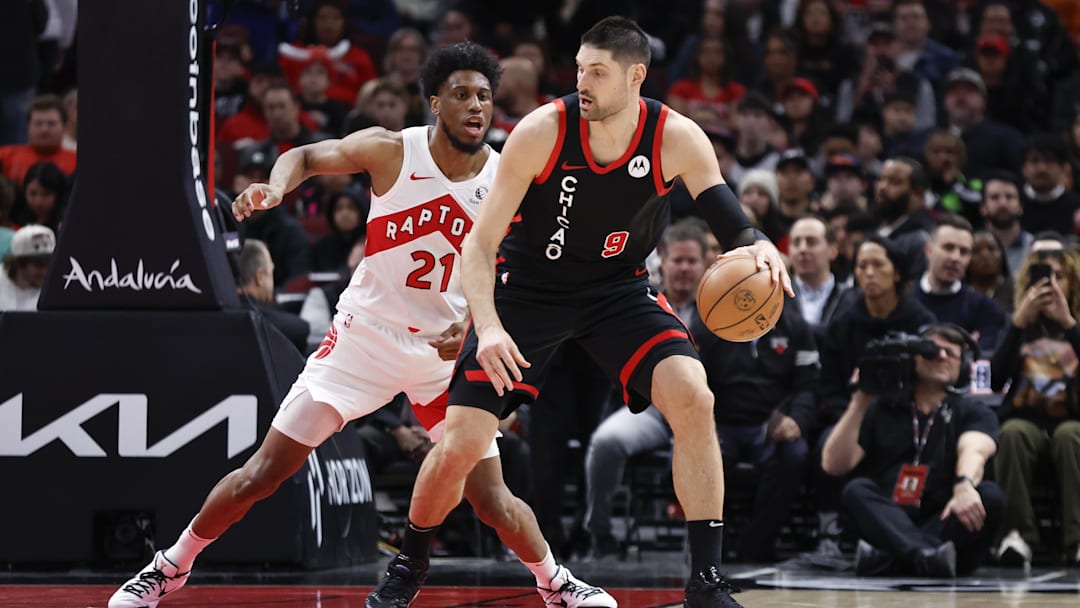 Jan 30, 2024; Chicago, Illinois, USA; Toronto Raptors forward Thaddeus Young (21) defends against Chicago Bulls center Nikola Vucevic (9) during the first half at United Center. Mandatory Credit: Kamil Krzaczynski-Imagn Images