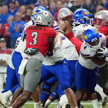 Dec 26, 2023; Phoenix, AZ, USA; Kansas Jayhawks running back Devin Neal (4) runs for a touchdown against the UNLV Rebels during the first half at Chase Field.