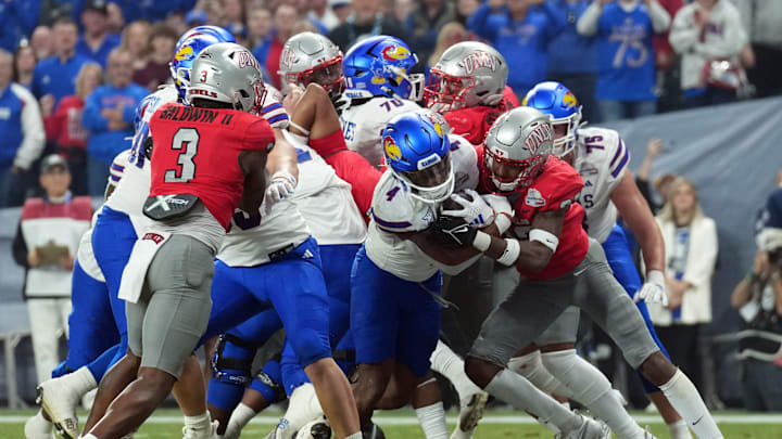 Dec 26, 2023; Phoenix, AZ, USA; Kansas Jayhawks running back Devin Neal (4) runs for a touchdown against the UNLV Rebels during the first half at Chase Field.