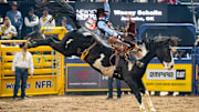 Wacey Schalla and the horse Trooper winning a fourth place check in round three of the bareback riding at the 2025 NFR