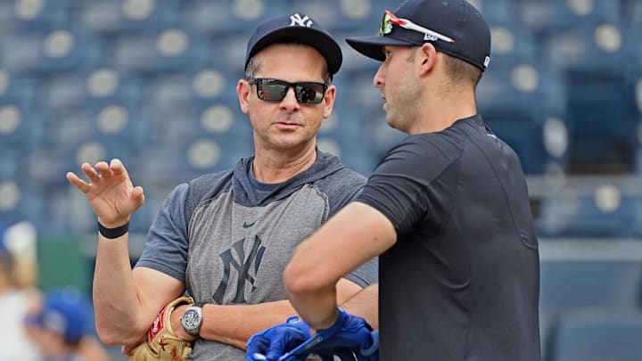 Aug 9, 2021; Kansas City, Missouri, USA;  New York Yankees manager Aaron Boone (left) talks with left fielder Joey Gallo (right) during batting practice prior to a game against the Kansas City Royals at Kauffman Stadium. Mandatory Credit: Peter Aiken-Imagn Images