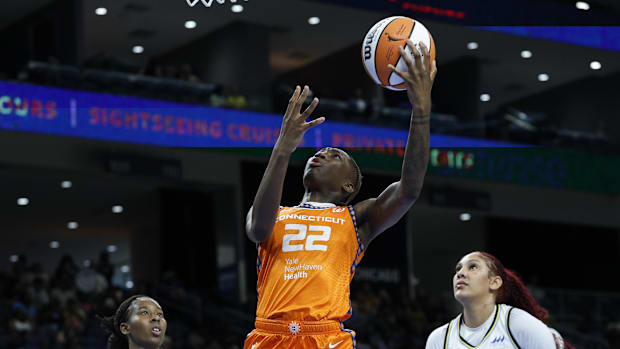 Connecticut Sun guard Saniya Rivers drives to the basket while wearing an orange uniform