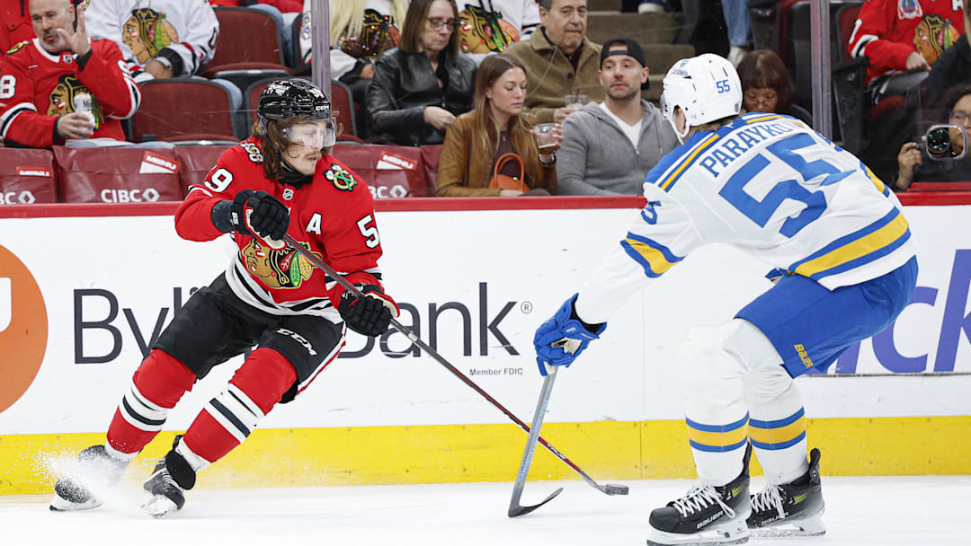 Apr 11, 2026; Chicago, Illinois, USA; Chicago Blackhawks left wing Tyler Bertuzzi (59) passes the puck against St. Louis Blues defenseman Colton Parayko (55) during the first period at United Center. Mandatory Credit: Kamil Krzaczynski-Imagn Images