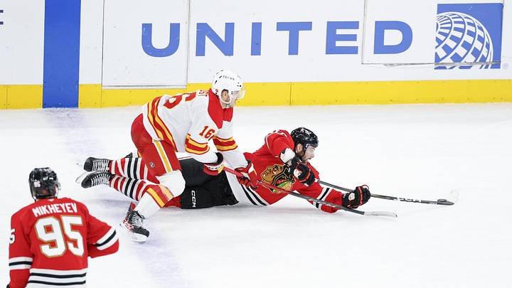 Jan 15, 2026; Chicago, Illinois, USA; Chicago Blackhawks center Jason Dickinson (16) defends against Calgary Flames center Morgan Frost (16) during the third period at United Center. Mandatory Credit: Kamil Krzaczynski-Imagn Images
