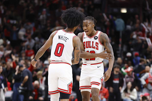 Chicago Bulls guard Coby White (0) celebrates with guard Ayo Dosunmu (12