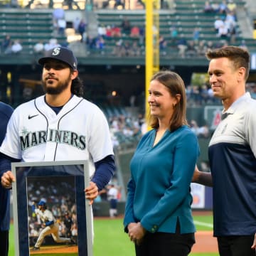 Seattle Mariners' chairman John Stanton (left), president of business operations Catie Griggs (second from right) and president of baseball operations Jerry Dipoto (right) present the MLB August AL Reliever of the Month award to Andres Munoz (second from left).