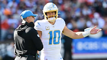 Nov 3, 2024; Cleveland, Ohio, USA; Los Angeles Chargers quarterback Justin Herbert (10) talks to head coach Jim Harbaugh during the first quarter against the Cleveland Browns at Huntington Bank Field. Mandatory Credit: Ken Blaze-Imagn Images