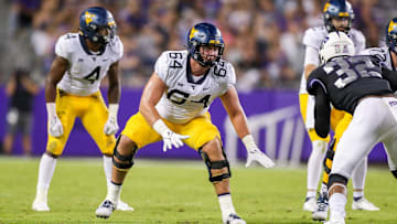 Oct 23, 2021; Fort Worth, Texas, USA; West Virginia Mountaineers offensive lineman Wyatt Milum (64) steps back to block during the third quarter against the TCU Horned Frogs at Amon G. Carter Stadium. Mandatory Credit: Ben Queen-Imagn Images