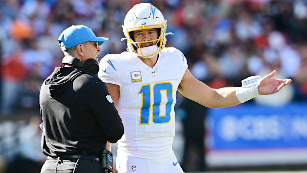 Nov 3, 2024; Cleveland, Ohio, USA; Los Angeles Chargers quarterback Justin Herbert (10) talks to head coach Jim Harbaugh duri