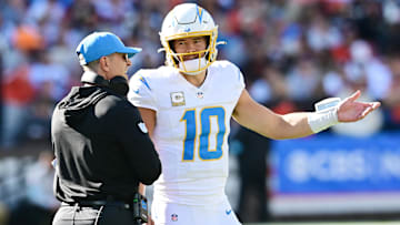 Chargers head coach Jim Harbaugh speaks to quarterback Justin Herbert