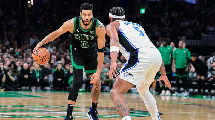 Dec 15, 2023; Boston Celtics forward Jayson Tatum (0)  against Orlando Magic forward Paolo Banchero (5) during the second half at TD Garden. 