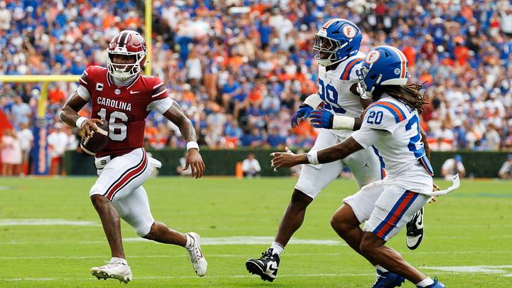 Oct 10, 2026; Gainesville, Florida, USA;  South Carolina Gamecocks quarterback LaNorris Sellers (16) runs from Florida Gators defenders Emmanuel Oyebadejo (99) and Kanye Clark (20) during the first half at Ben Hill Griffin Stadium.  Mandatory Credit: Matt Pendleton-Imagn Images