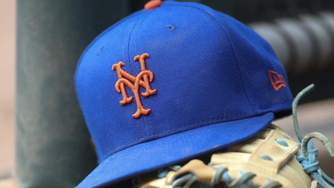 Jul 13, 2022; Atlanta, Georgia, USA; A detailed view of a New York Mets hat and glove in the dugout against the Atlanta Braves in the eighth inning at Truist Park. 