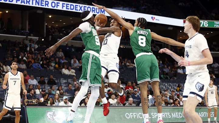 Oct 8, 2025; Memphis, Tennessee, USA; Memphis Grizzlies guard Javon Small (10) drives to the basket as Boston Celtics forward Chris Boucher (99) and forward Josh Minott (8) defend during the third quarter at FedExForum. Mandatory Credit: Petre Thomas-Imagn Images