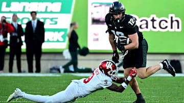 Nov 2, 2024; East Lansing, Michigan, USA;  Michigan State Spartans tight end Jack Velling (12) evades Indiana Hoosiers defensive back Jamier Johnson (9) during the third quarter at Spartan Stadium. Mandatory Credit: Dale Young-Imagn Images