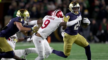 Dec 20, 2024; Notre Dame, Indiana, USA; Notre Dame Fighting Irish running back Jadarian Price (24) runs against Indiana Hoosiers defensive back Jamier Johnson (9) during the first half at Notre Dame Stadium. Mandatory Credit: Trevor Ruszkowski-Imagn Images