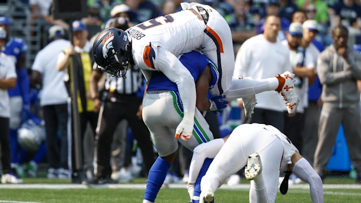 Sep 8, 2024; Seattle, Washington, USA; Denver Broncos linebacker Baron Browning (5) tackles Seattle Seahawks running back Kenneth Walker III (9) during the second quarter at Lumen Field. 