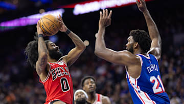 Jan 2, 2024; Philadelphia, Pennsylvania, USA; Chicago Bulls guard Coby White (0) drives against Philadelphia 76ers center Joel Embiid (21) during the third quarter at Wells Fargo Center. Mandatory Credit: Bill Streicher-Imagn Images