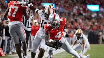 Ohio State Buckeyes wide receiver Jeremiah Smith (4) gets a block from wide receiver Carnell Tate (17) on Minnesota Golden Gophers defensive back Darius Green (12) during the NCAA football game at Ohio Stadium in Columbus on Oct. 4, 2025.