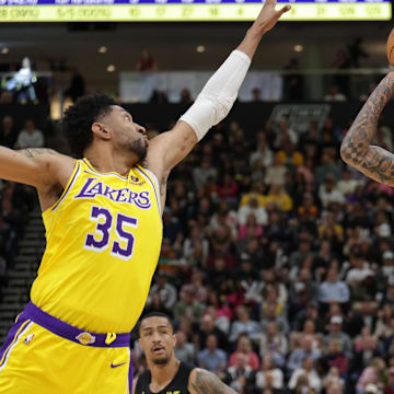 Feb 14, 2024; Salt Lake City, Utah, USA;  Utah Jazz guard Jordan Clarkson (00) shoots the ball past the arm of Los Angeles Lakers forward Christian Wood (35) during the second half at Delta Center. Mandatory Credit: Chris Nicoll-Imagn Images