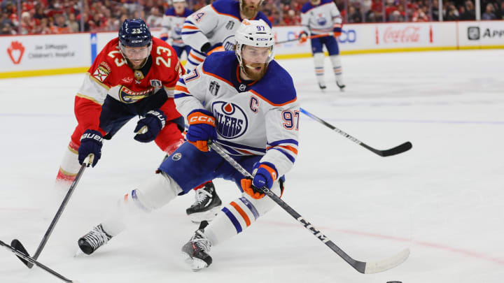Jun 24, 2024; Sunrise, Florida, USA; Edmonton Oilers forward Connor McDavid (97) controls the puck as Florida Panthers forward Carter Verhaeghe (23) reaches to defend during the first period in game seven of the 2024 Stanley Cup Final at Amerant Bank Arena. Mandatory Credit: Sam Navarro-USA TODAY Sports