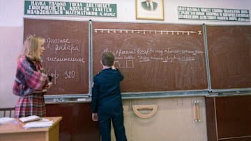 Teacher Watching Student at Blackboard