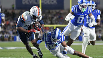 Nov 15, 2025; Durham, North Carolina, USA;  Virginia Cavaliers wide receiver Trell Harris (11) takes a hit from Duke Blue Devils saftey Ma'khi Jones (26) during the third quarter at Wallace Wade Stadium. Mandatory Credit: Zachary Taft-Imagn Images