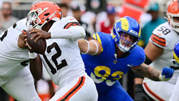 Los Angeles Rams defensive tackle Jack Heflin grabs the jersey of Cleveland Browns quarterback Shedeur Sanders