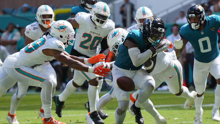 Sep 8, 2024; Miami Gardens, Florida, USA;  Miami Dolphins safety Jevon Holland (8) punches the ball away from Jacksonville Jaguars running back Travis Etienne Jr. (1) causing a fumble that was recovered by the Dolphins in the end zone during the third quarter at Hard Rock Stadium. Mandatory Credit: Jim Rassol-Imagn Images