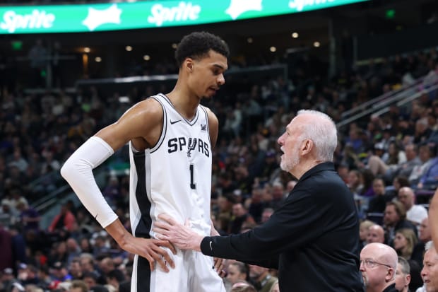 Spurs center Victor Wembanyama and coach Gregg Popovich speak during the first quarter against the Utah Jazz at Delta Center.