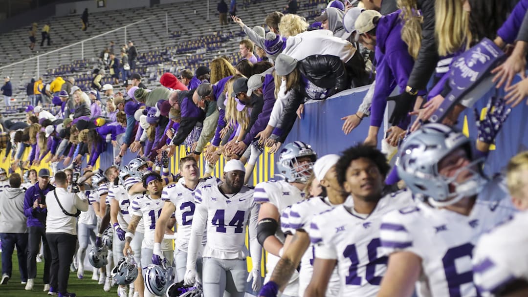 Oct 19, 2024; Morgantown, West Virginia, USA; Kansas State Wildcats players celebrate with fans after defeating the West Virginia Mountaineers at Mountaineer Field at Milan Puskar Stadium. Mandatory Credit: Ben Queen-Imagn Images