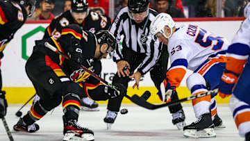 Nov 19, 2024; Calgary, Alberta, CAN; Calgary Flames center Nazem Kadri (91) and New York Islanders center Casey Cizikas (53) face off for the puck during the third period at Scotiabank Saddledome. Mandatory Credit: Sergei Belski-Imagn Images