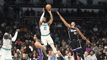 Jan 10, 2024; Charlotte, North Carolina, USA; Charlotte Hornets forward Miles Bridges (0) shoots past the defense of Sacramento Kings forward Keegan Murray (13) during the second half at the Spectrum Center. Mandatory Credit: Sam Sharpe-Imagn Images