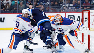 Winnipeg Jets goalie Arvid Holm (75) jostles for position with Edmonton Oilers defenseman Max Wanner (88)