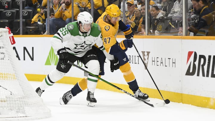 Apr 16, 2025; Nashville, Tennessee, USA;  Nashville Predators right wing Michael McCarron (47) and Dallas Stars defenseman Thomas Harley (55) battle for the puck during the third period at Bridgestone Arena. Mandatory Credit: Steve Roberts-Imagn Images