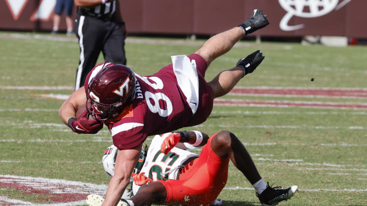 Oct 15, 2022; Blacksburg, Virginia, USA;  Virginia Tech Hokies tight end Nick Gallo (86) is tripped up by Miami Hurricanes cornerback Te'Cory Couch (23) during the second half at Lane Stadium. Mandatory Credit: Reinhold Matay-USA TODAY Sports