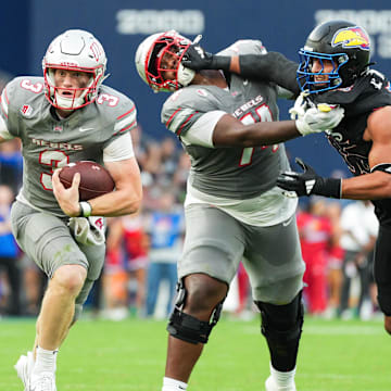 Sep 13, 2024; Kansas City, Kansas, USA; UNLV Rebels quarterback Matthew Sluka (3) runs the ball against Kansas Jayhawks defensive end Dean Miller (45) during the first half at Children's Mercy Park. Mandatory Credit: Jay Biggerstaff-Imagn Images