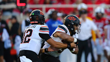 Oct 25, 2025; Lubbock, Texas, USA;  Oklahoma State Cowboys quarterback Noah Walters (12) hands the ball to running back Sesi Vailahi (3) in the second half during the game against the Texas Tech Red Raiders at Jones AT&T Stadium. Mandatory Credit: Michael C. Johnson-Imagn Images