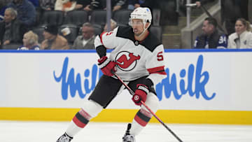 Oct 21, 2025; Toronto, Ontario, CAN; New Jersey Devils defenseman Brenden Dillon (5) controls the puck against the Toronto Maple Leafs during the third period at Scotiabank Arena. Mandatory Credit: John E. Sokolowski-Imagn Images