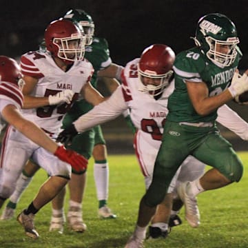 Senior tailback Owen Gorham (20) runs the ball for the Mendon varsity football team in Michigan. The Hornets won their playoff opener after Grand Rapids Sacred Heart forfeited due to a scheduling conflict.