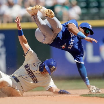 Seattle Mariners right fielder Dominic Canzone (bottom) is safe at second as Toronto Blue Jays second baseman Leo Jimenez (top) tumbles over on July 7 at T-Mobile Park.