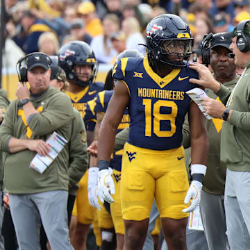 West Virginia University head coach Rich Rodriguez giving instructions to Bandit/running back Curtis Jones Jr. against Colorado.