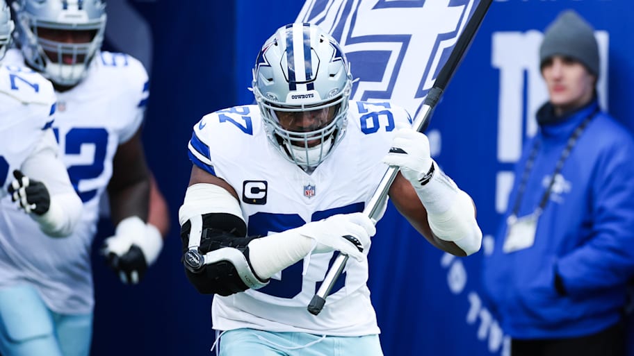 Cowboys defensive tackle Osa Odighizuwa (97) takes the field with a flag honoring late defensive end Marshawn Kneeland.