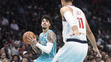 Nov 22, 2025; Charlotte, North Carolina, USA; Charlotte Hornets guard LaMelo Ball (1) looks to pass as he is defended by Los Angeles Clippers center Brook Lopez (11) during the first half at the Spectrum Center. Mandatory Credit: Sam Sharpe-Imagn Images