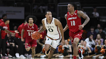 Jan 10, 2024; Coral Gables, Florida, USA; Miami Hurricanes guard Matthew Cleveland (0) dribbles the basketball ahead of Louisville Cardinals forward Kaleb Glenn (10) during the second half at Watsco Center. Mandatory Credit: Sam Navarro-Imagn Images